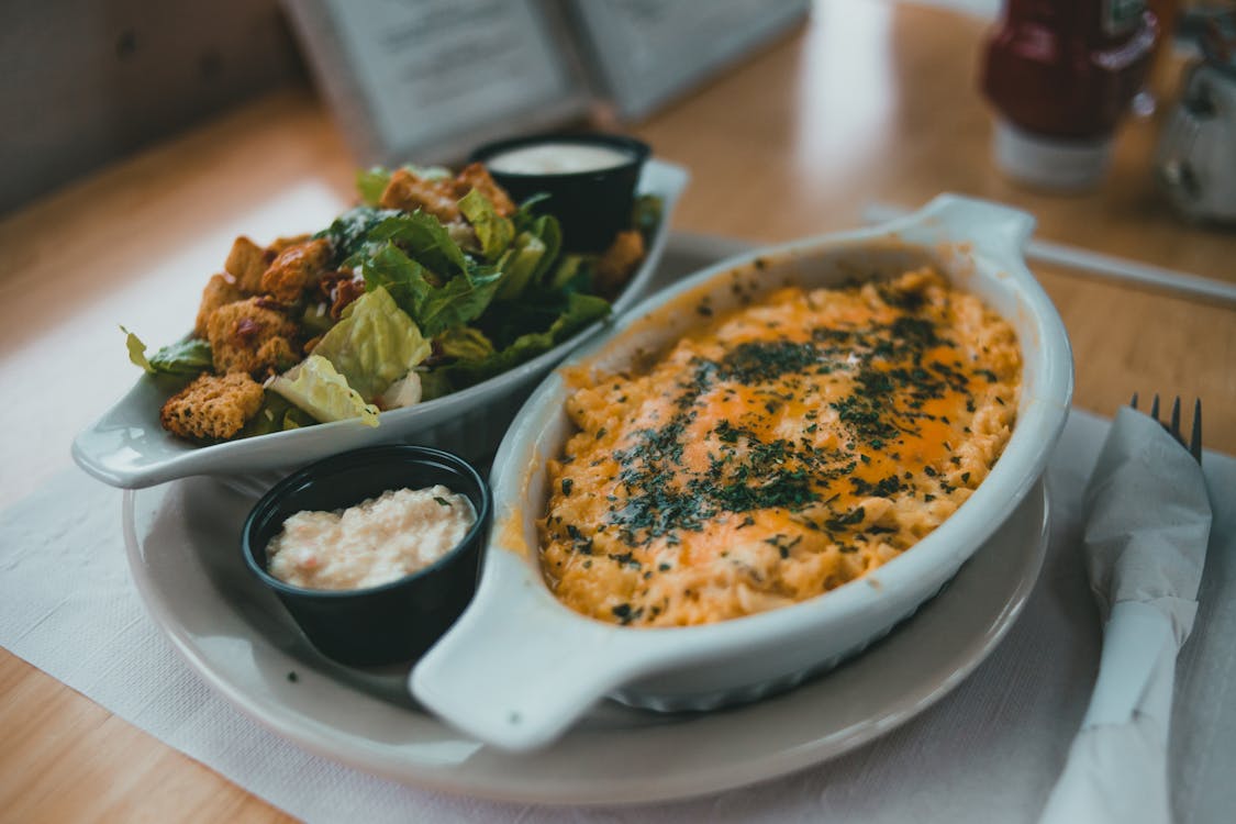 Mac and cheese served alongside a fresh salad — the perfect comfort food dinner pairing